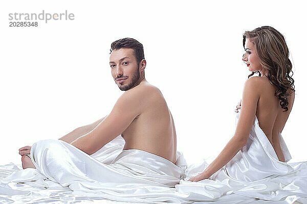 Attraktive Sexualpartner posieren im Bett  vor weißem Hintergrund