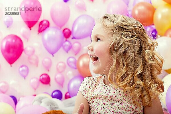 Porträt von adorable fröhliches Mädchen auf Luftballons Hintergrund
