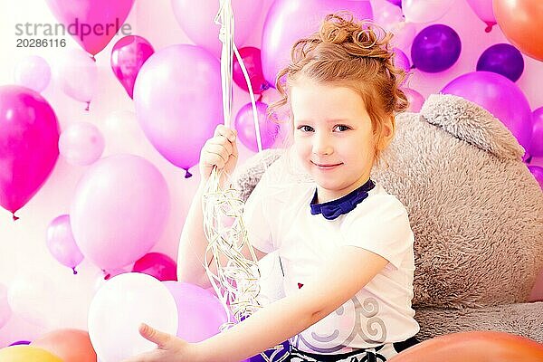 Porträt von lächelnden Mädchen auf bunten Luftballons Hintergrund