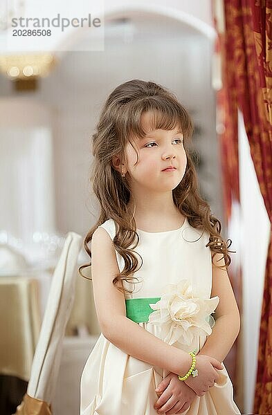 Bild eines schönen langhaarigen Mädchens  das in einem schicken Kleid posiert