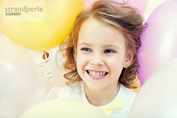 Porträt eines glücklichen Kindes auf Luftballons Hintergrund  Nahaufnahme