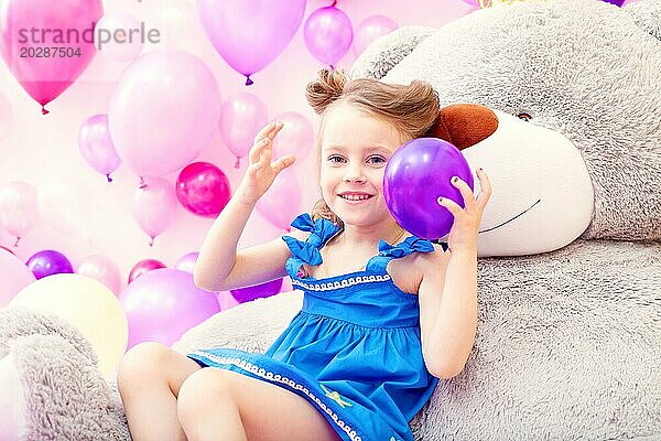 Bild von fröhlichen kleinen Mädchen spielt mit Luftballon im Spielzimmer