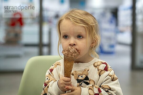 Innenaufnahme  Mädchen  2-3 Jahre  blond  isst Schokoladeneis  Eis  Waffel  Mund verschmiert  Logo Apotheke  Stuttgart  Baden-Württemberg  Deutschland  Europa