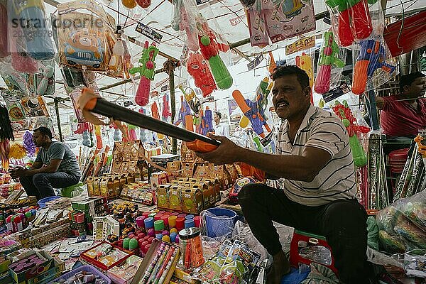 Ein Verkäufer verkauft Holi Artikel auf einem Straßenmarkt vor dem Holi Fest am 23. März 2024 in Guwahati  Assam  Indien. Holi ist das hinduistische Fest der Farben. Es wird in Indien mit großer Freude gefeiert