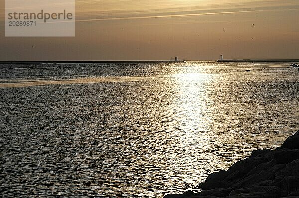 Sonnenuntergang mit funkelnder Reflexion auf dem Wasser  Silhouette von Leuchttürmen am Horizont  Porto  Nordportugal  Portugal  Europa