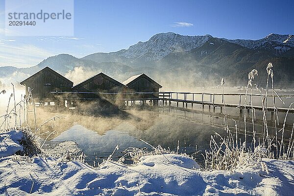 Bootshütten im Morgenlicht vor Bergen  See  Schnee  Winter  Nebel  Kochelsee  Alpenvorland  Bayern  Deutschland  Europa