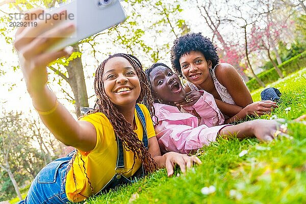 Drei afrikanische Freundinnen machen ein Selfie in einem Stadtpark
