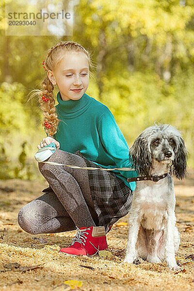 Bild von schönen Mädchen mit Hund im Herbst Park spazieren