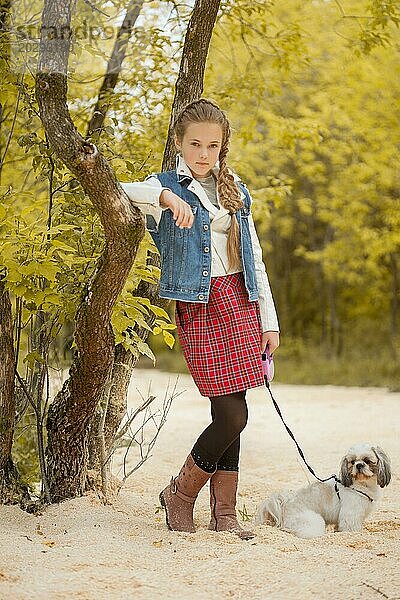 Bild von hübschen kleinen Modell posiert mit Hund im Park