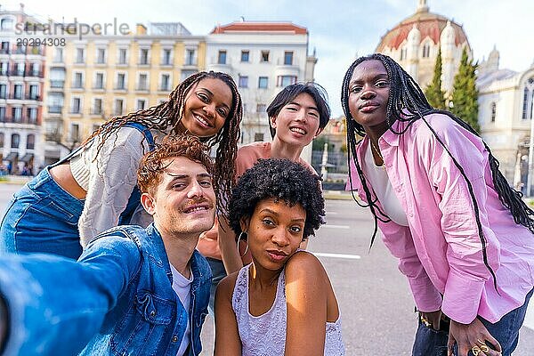 Fröhliche  heterogene junge Männer und Frauen machen ein Selfie in der Stadt