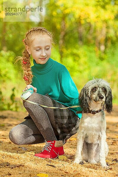 Bild von liebenswerten kleinen Mädchen posiert mit Hund im Freien