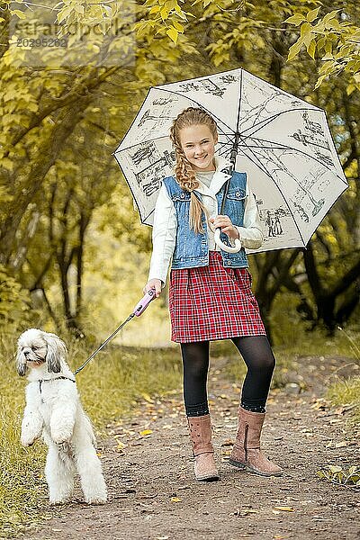 Bild von lächelnden Fashionista posiert mit Hund im Park