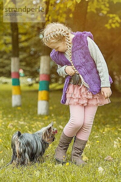 Bild von liebenswerten kleinen Mädchen spielen mit ihrem Welpen im Park