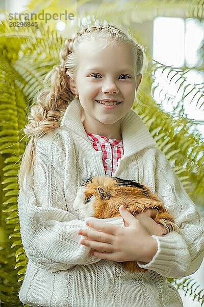 Porträt eines hübschen lächelnden kleinen Mädchens  das mit einem Haustier posiert