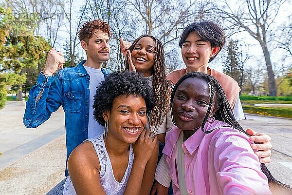 Persönliche Perspektive einer Gruppe junger  fröhlicher und unterschiedlicher Freunde  die ein Gruppen Selfie in einem Park machen