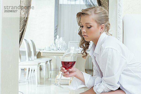 Schönes junges Mädchen betrachtet nachdenklich ein Glas Wein  Nahaufnahme