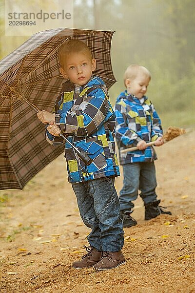 Bild von niedlichen Zwillingsbrüder zu Fuß im Herbst Park
