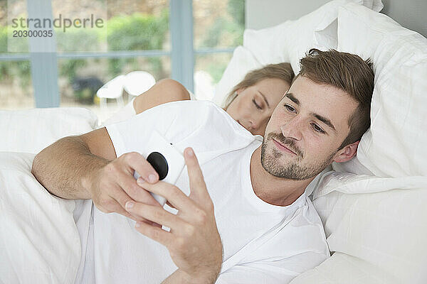 Mann im Bett mit Smartphone