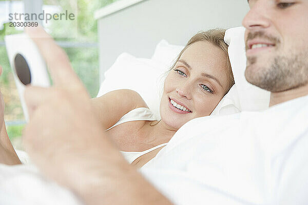 Paar im Bett mit Smartphone