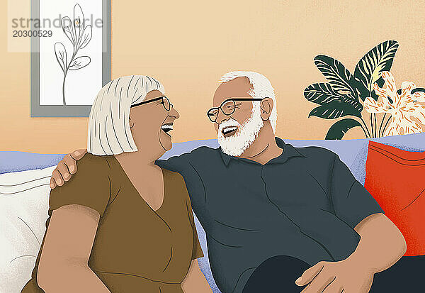 Glückliches älteres Paar  das lacht und sich auf dem Sofa im Wohnzimmer anfreundet