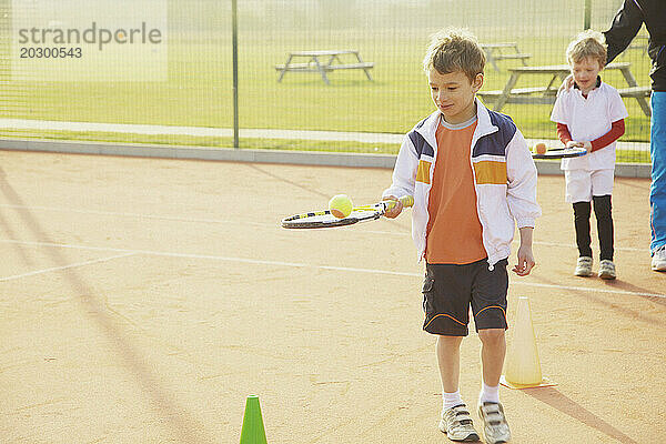 Kinder üben Tennis