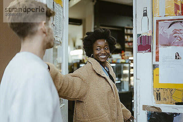 Lächelnde Freundin schaut ihren Freund an  während sie den Supermarkt betritt
