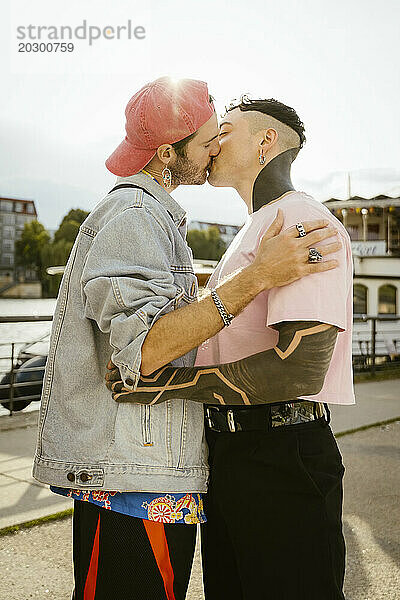 Seitenansicht eines schwulen Paares  das sich küsst  während es auf der Promenade steht