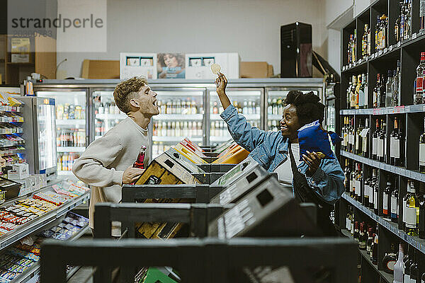 Verspieltes Paar hat Spaß beim Einkaufen im Supermarkt