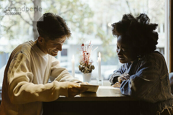 Freund und Freundin lesen Menükarte  während sie an der Bar sitzen