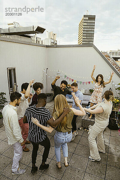 Eine Gruppe von Freunden tanzt auf einer Party auf der Dachterrasse