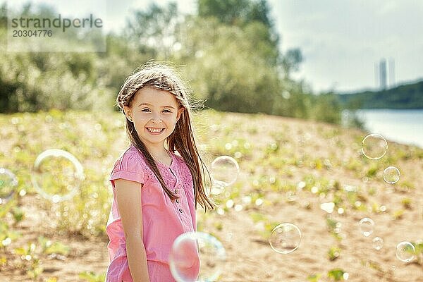 Porträt eines fröhlichen kleinen Mädchens  das vor der Kamera posiert
