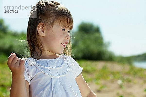 Porträt eines fröhlichen kleinen Mädchens  das im Park posiert