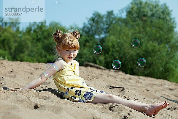Bild eines amüsanten rothaarigen Mädchens  das sich am Strand ausruht