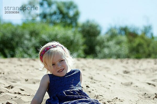 Porträt eines hübschen blonden Mädchens  das sich am Strand ausruht