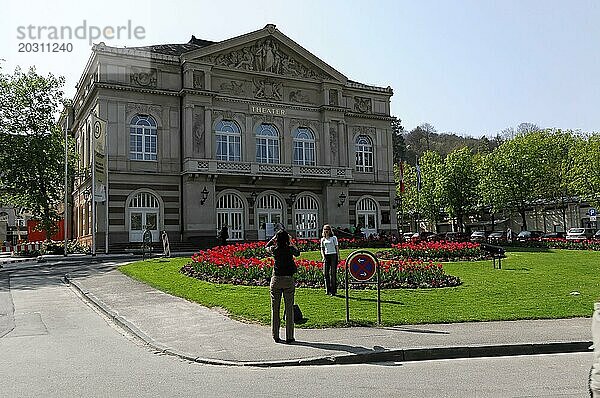 THEATER  Vor einem klassischen Theatergebäude spazieren Menschen in einem Park mit bunten Tulpen  Baden-Baden  Baden-Württemberg  Deutschland  Europa