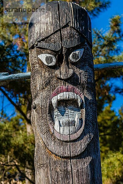 Nahaufnahme des geschnitzten Gesichts eines hölzernen Totempfahls  der vor langer Zeit dazu diente  Gemeinschaften vor dem Bösen zu schützen  in einem öffentlichen Park in der Nähe von Daejeon  Südkorea  Asien