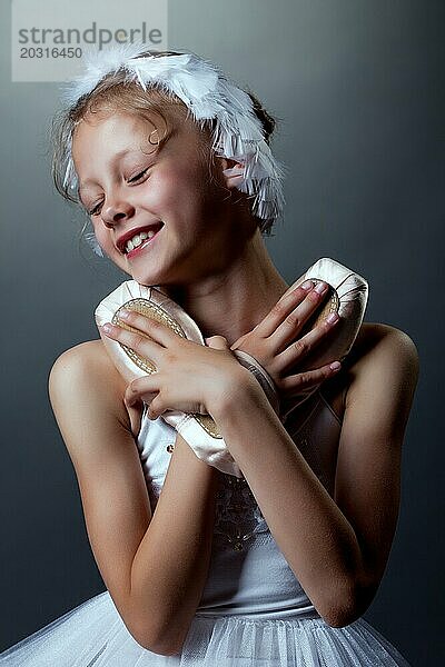 Porträt der fröhlichen kleinen Ballerina knuddelt pointes