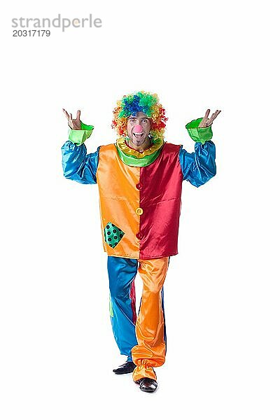 Fröhlicher Clown in Kostüm und bunter Perücke  vor weißem Hintergrund