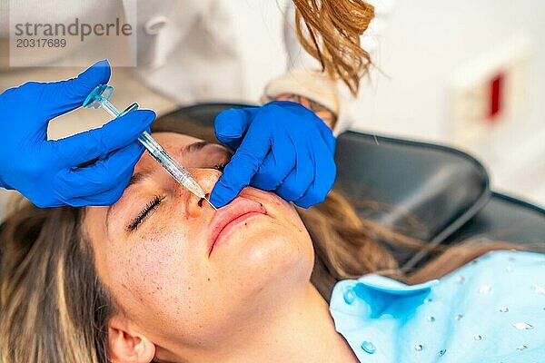 Nahaufnahme einer erwachsenen kaukasischen Frau  die sich in einer Schönheitsklinik eine Botox Injektion in die Lippen geben lässt