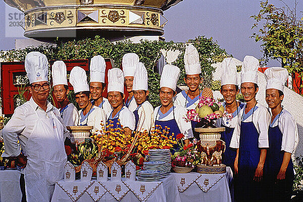 Vietnam. Ho Chi Minh Stadt. Köche des Rex Hotels posieren im Freien mit einer Essenspräsentation.