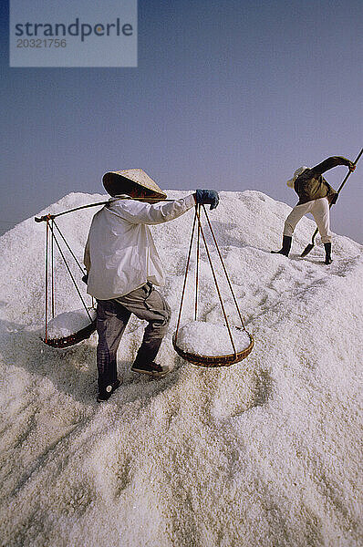 Vietnam. Industrie. Cam Ranh Bucht. Männer ernten Salz.