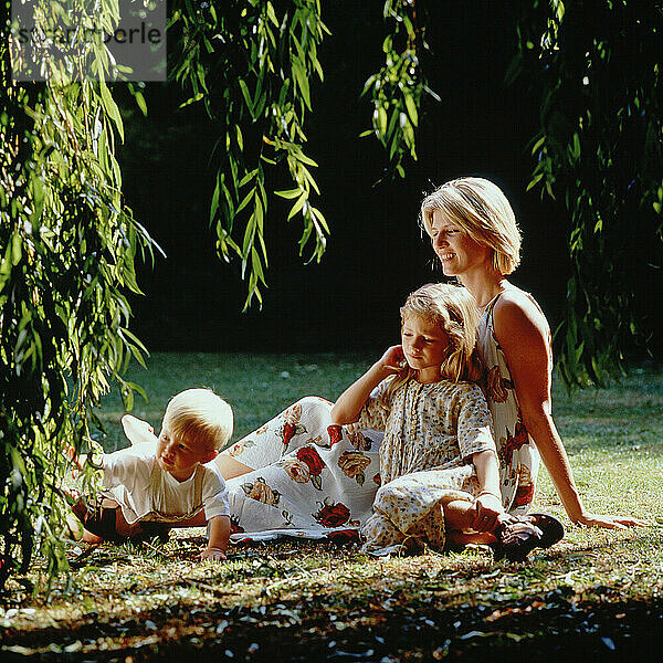 Familie. Mutter mit Kindern  Sohn und Tochter entspannen im Garten.