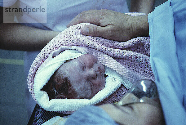 Medizinisches Krankenhaus. Geburt. Nahaufnahme eines neugeborenen Babys in den Armen der Mutter.