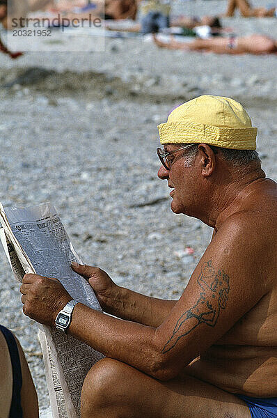 Großbritannien. England. Southend. Nahaufnahme eines Mannes  der am Strand Zeitung liest.