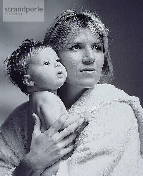 Familie. Schwarz-Weiß-Porträt von Mutter und Baby im Innenbereich.
