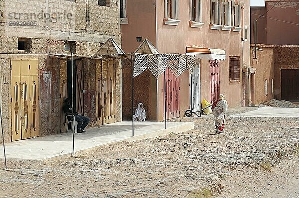 Tinerhir  Menschen ruhen in der Nähe von traditionellen Gebäuden entlang einer staubigen Straße  Südlicher hoher Atlas  Marokko  Afrika