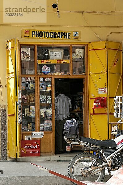 Tinerhir  Der gelbe Eingang eines kleinen Fotogeschäfts mit Büchern und Bildern  Südlicher hoher Atlas  Marokko  Afrika