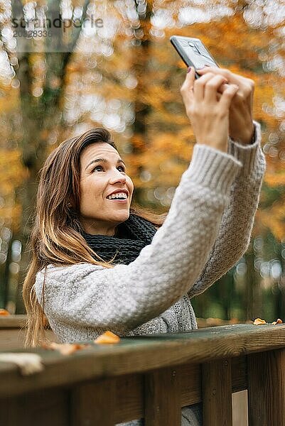 Schöne junge glückliche Frau nimmt Selfie mit Smartphone im Herbst Park. Saison  Technologie und Menschen Konzept