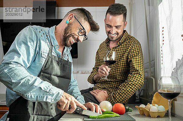 Ein glückliches  verliebtes schwules Paar steht in der Küche. Sie kochen Abendessen zusammen zu Hause. Hohe Qualität der Fotografie