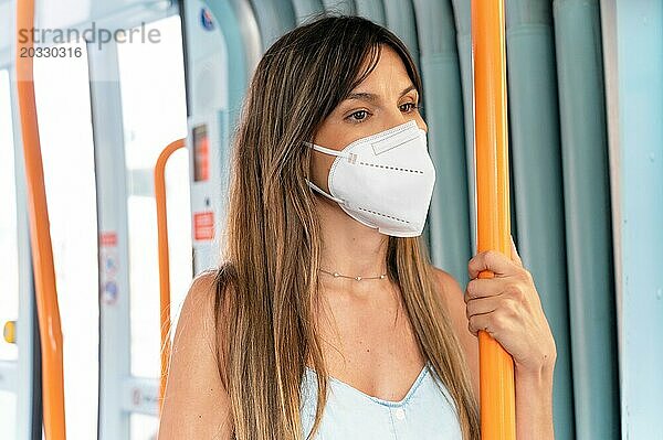 Frau Passagier trägt medizinische Hygiene schützen Maske. Stehend in U Bahn Zug Pendler in der Stadt. Hohe Qualität Foto